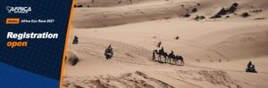 Rally motorcycles and a camel caravan in the sand dunes