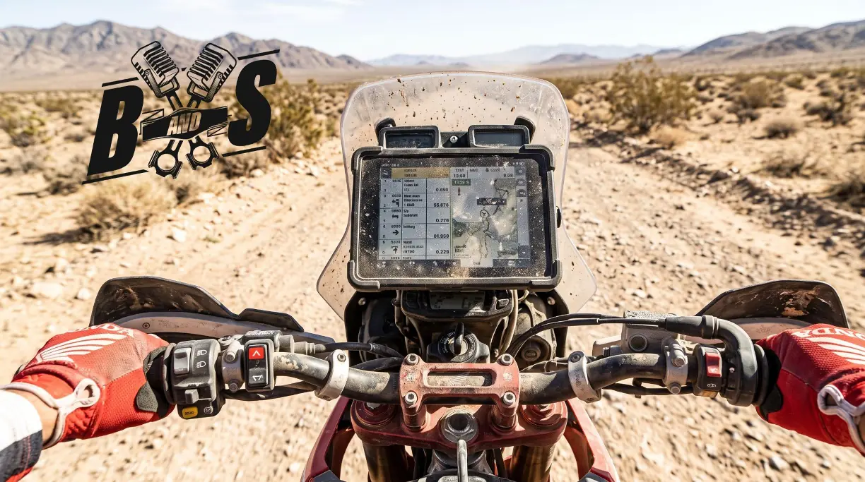 View over the handlebars of a rally motorcycle onto a digital roadbook display in a desert landscape, with the Bore and Stoke podcast logo on the left