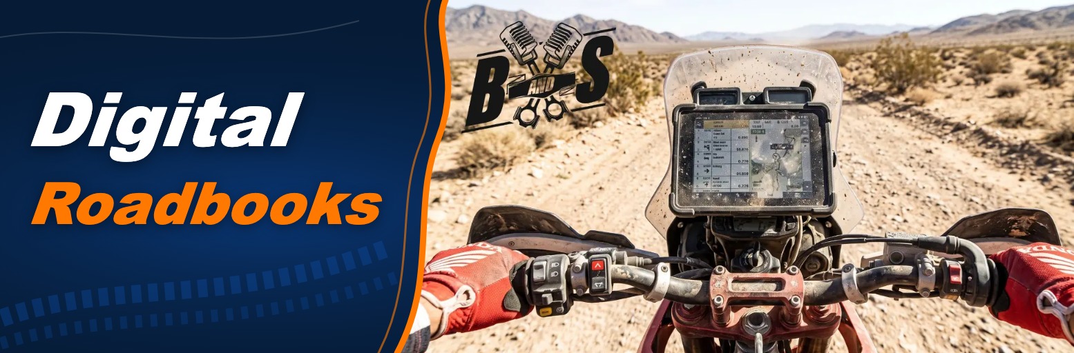 View over the handlebars of a rally motorcycle onto a digital roadbook display in the desert