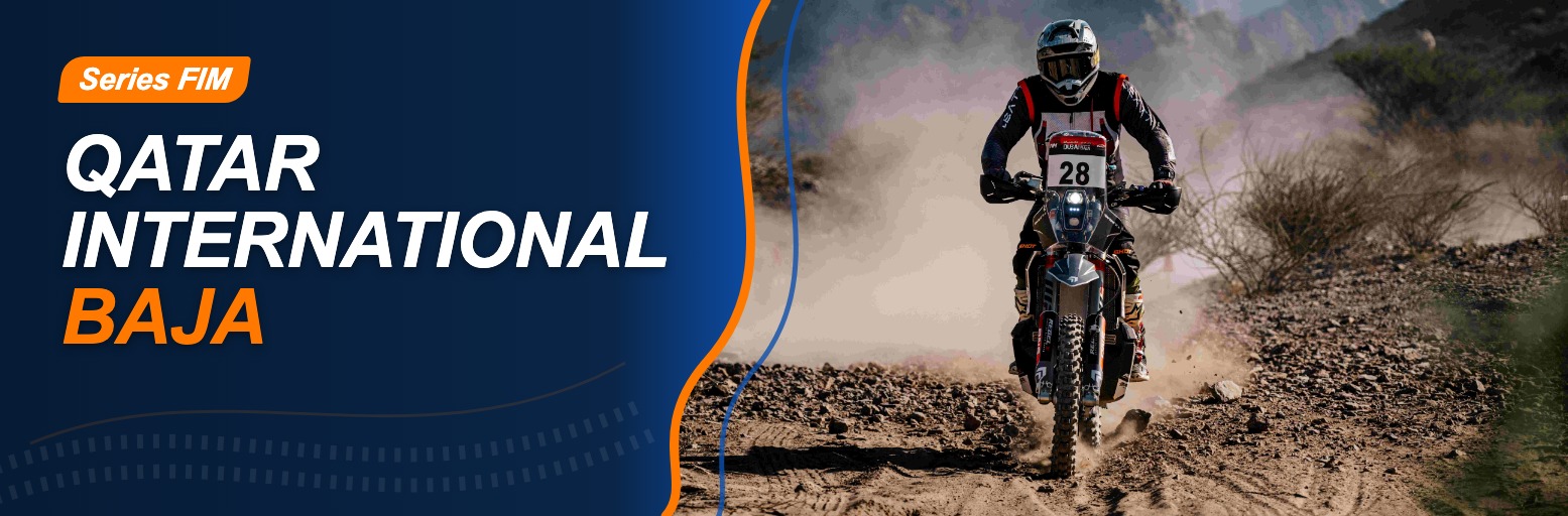 Rally motorcyclist on a dusty gravel track with mountains in the background